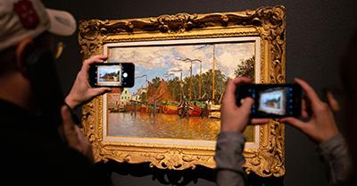 People taking photographs of a Monet painting