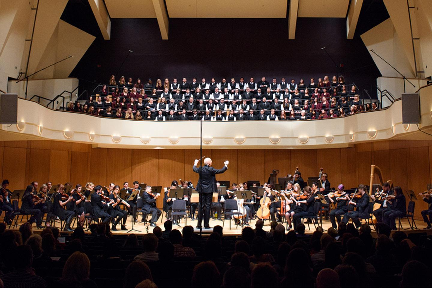 Full symphony orchestra and choir performing in the King Center Concert Hall