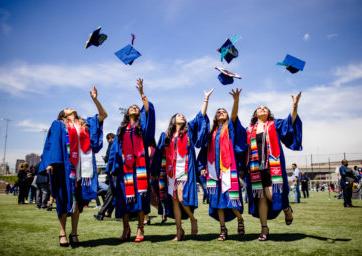 five women throwing their caps in the air at graduation