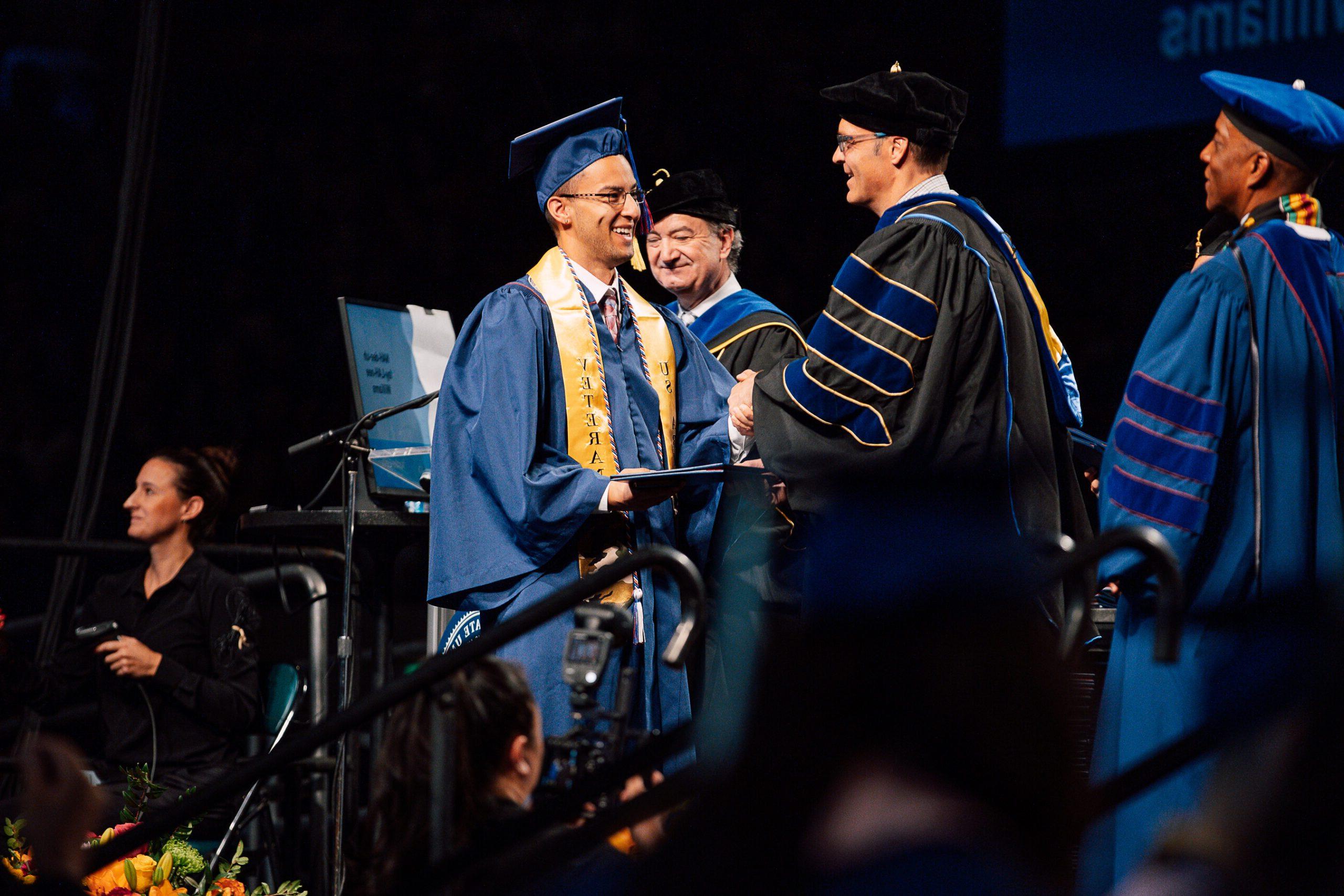 Photo of Political Science Student receiving his diploma.